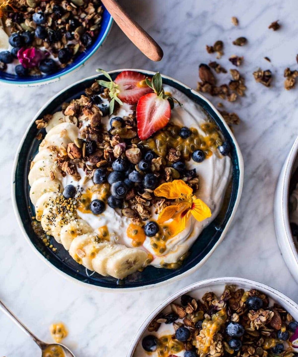 @halfbakedharvest - bowl de cafá da manhã - receitas com iogurte natural - verão - bowl de iogurte com frutas e granola em cima de uma mesa - https://stealthelook.com.br