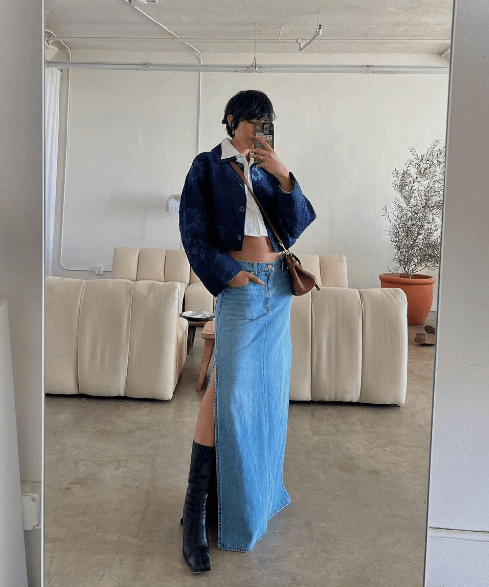 Stephanie Arant - saia longa jeans, bota preta de cano longo, camisa branca e jaqueta cropped jeans - inverno 2023 - inverno - foto na frente do espelho - https://stealthelook.com.br