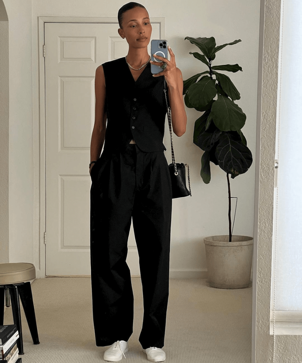 TyLynn Nguyen - calça preta alfaiataria, colete preto e tênis flat branco - looks com tênis branco - outono - foto na frente do espelho - https://stealthelook.com.br