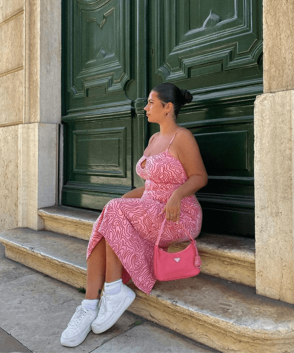 Freya Broni - vestido rosa midi estampado e tênis branco - looks com tênis branco - verão - sentada em uma escada na rua - https://stealthelook.com.br