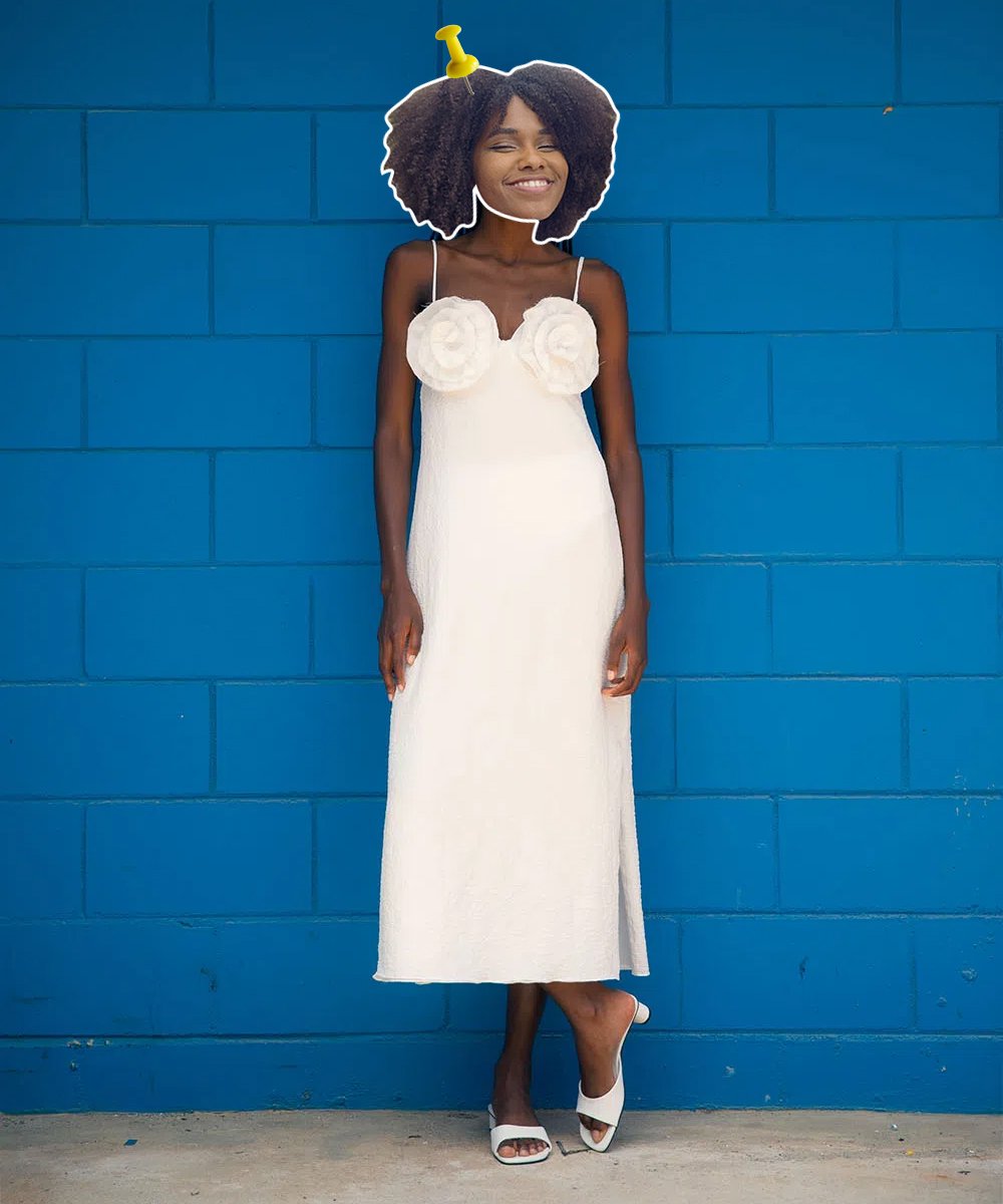 Clau Ribeiro - vestido branco midi com aplicações de flores no top branco - looks de casamento civil - outono - em pé na frente de uma parede azul - https://stealthelook.com.br