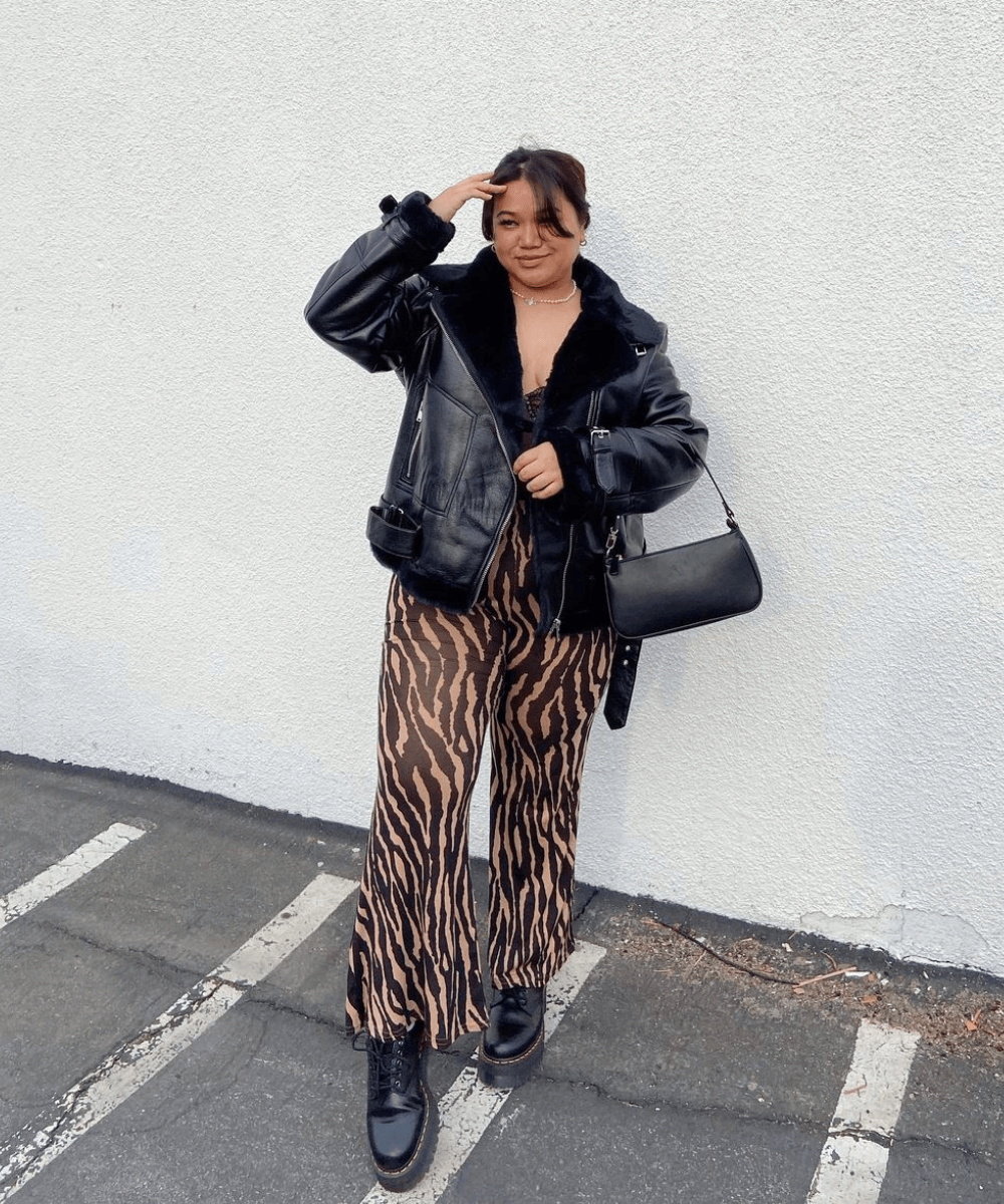 Lauren Licup - calça de animal print, jaqueta de couro preta e coturnos - looks de festa - inverno - em pé na rua - https://stealthelook.com.br