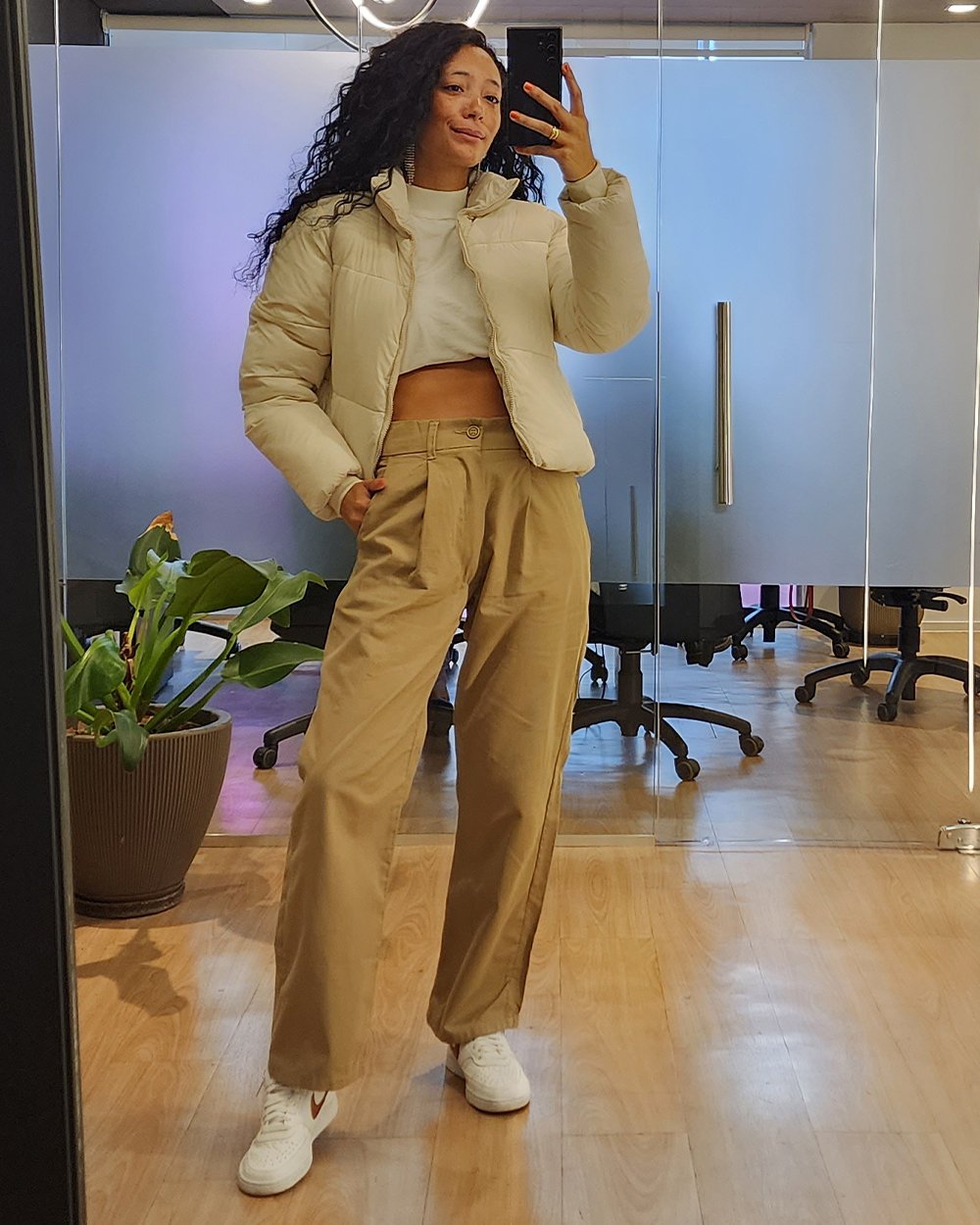 Rafaela Lopes - calça de alfaiataria bege, blusa de gola alta branca e jaqueta puffer - looks de inverno - inverno - foto na frente do espelho - https://stealthelook.com.br