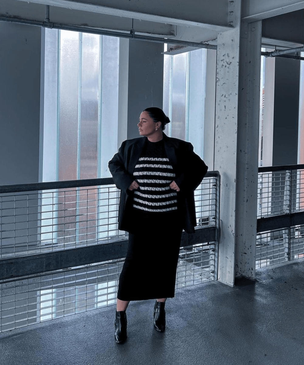 Grace Surguy - saia midi preta, trico listrado e blazer overzied - saia midi preta - inverno - mulher em pé olhando para o lado - https://stealthelook.com.br