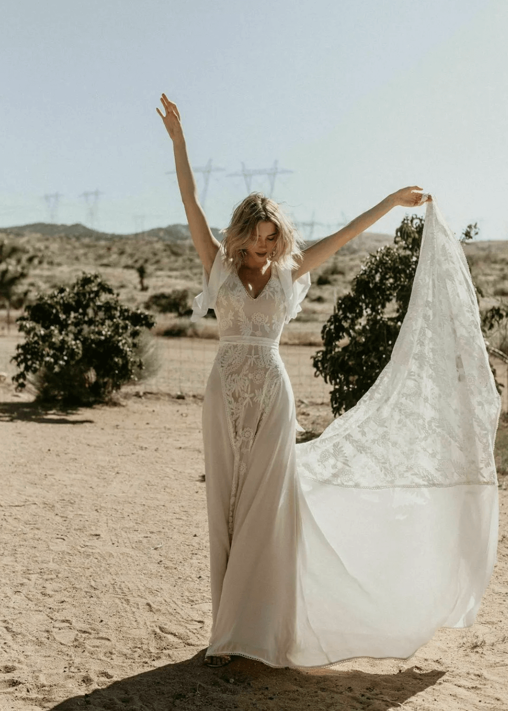 Hayley Romantic Bohemian Wedding Dress - vestido de noiva longo rendado e bordado - vestidos de noiva - outono - mulher em pé com os braços para cima - https://stealthelook.com.br