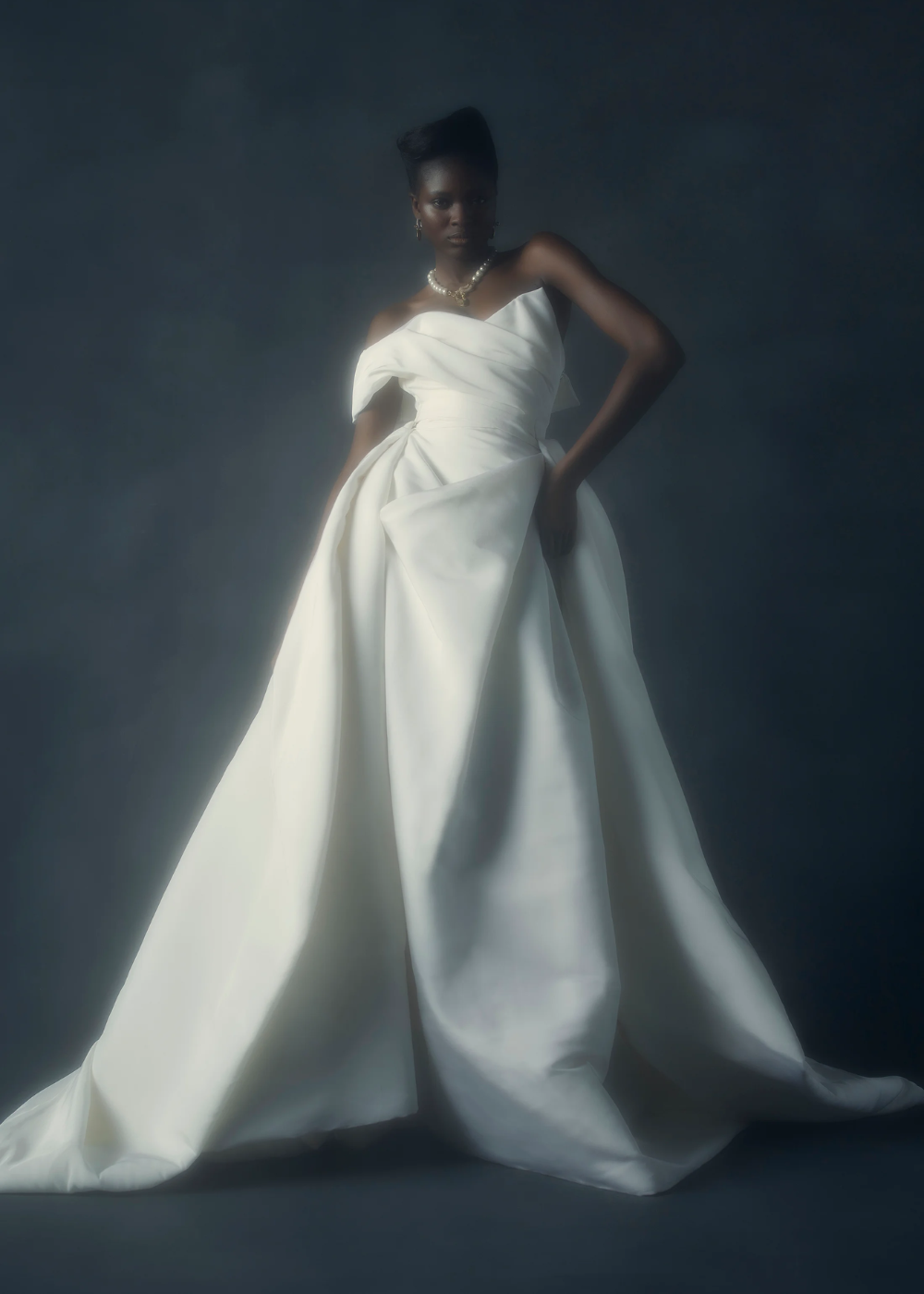 Freyja Dress by Vivienne Westwood - vestido de noiva com top assimétrico - vestidos de noiva - outono - mulher negra usando vestido de noiva em pé com fundo azul marinho - https://stealthelook.com.br