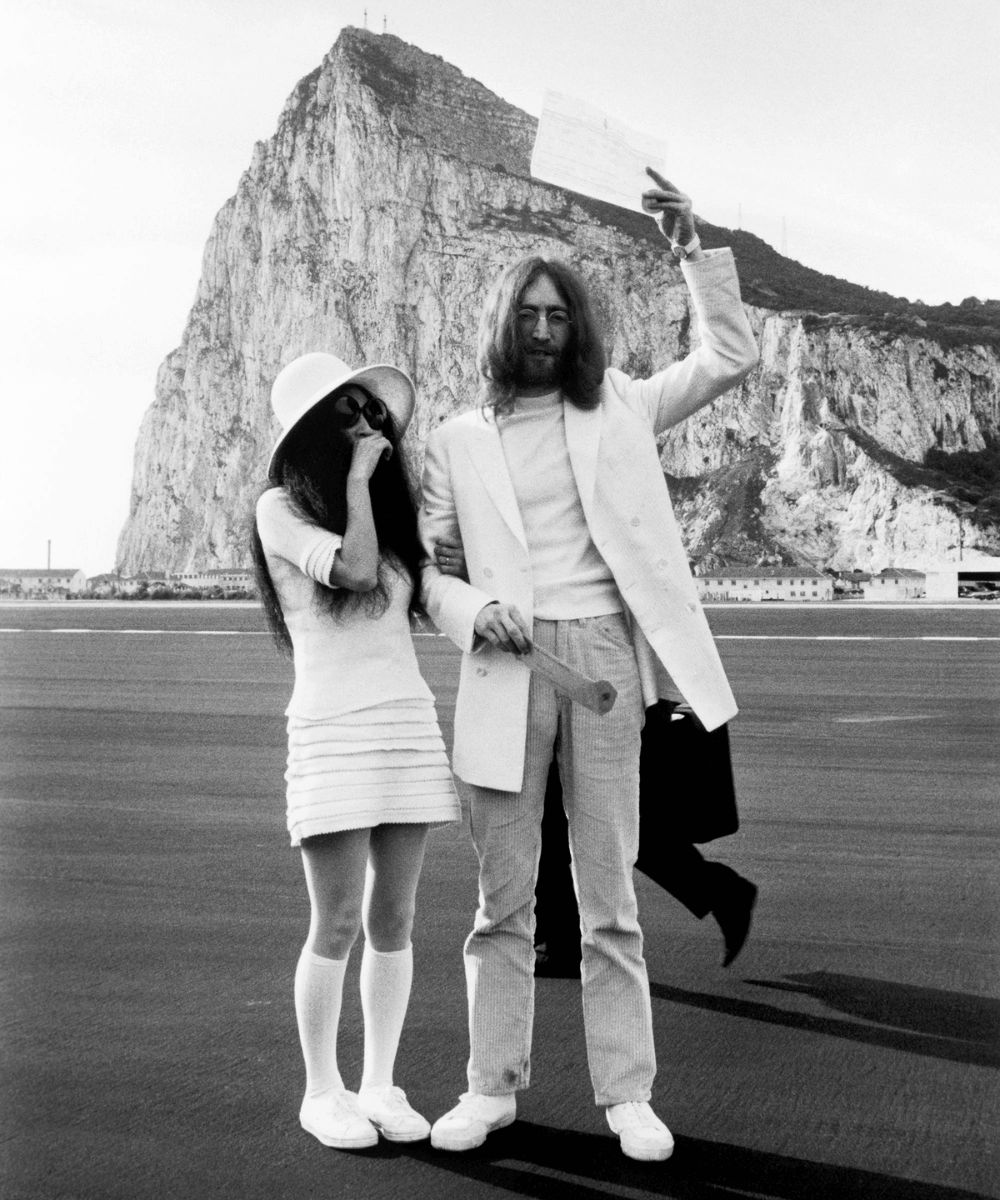Yoko Ono e John Lennon - roupas de casamento - anti-bride - verão - foto de arquivo preta e branca de casal na praia - https://stealthelook.com.br