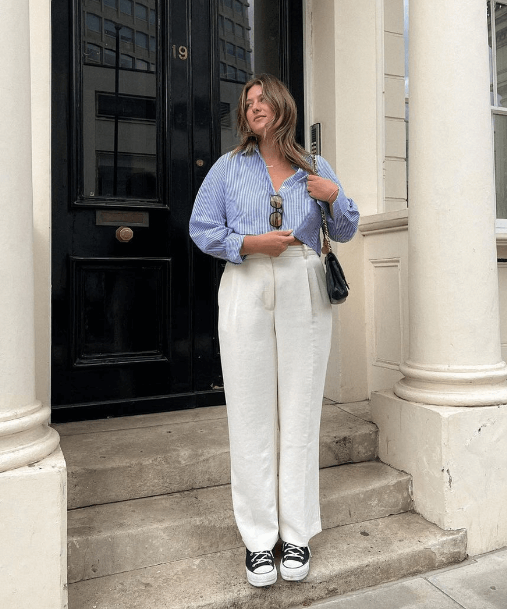 Raeann Langas - calça de alfaiataria branca, camisa listrada azul estilo cropped - calça de alfaiataria branca - verão - mulher loira em pé na rua - https://stealthelook.com.br