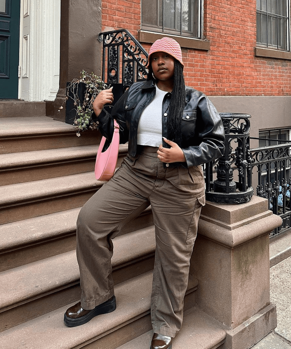 Aniyah Morinia - calça cargo, jaqueta preta, gorro de crochê rosa - looks de inverno - inverno - mulher negra em pé em uma escada - https://stealthelook.com.br