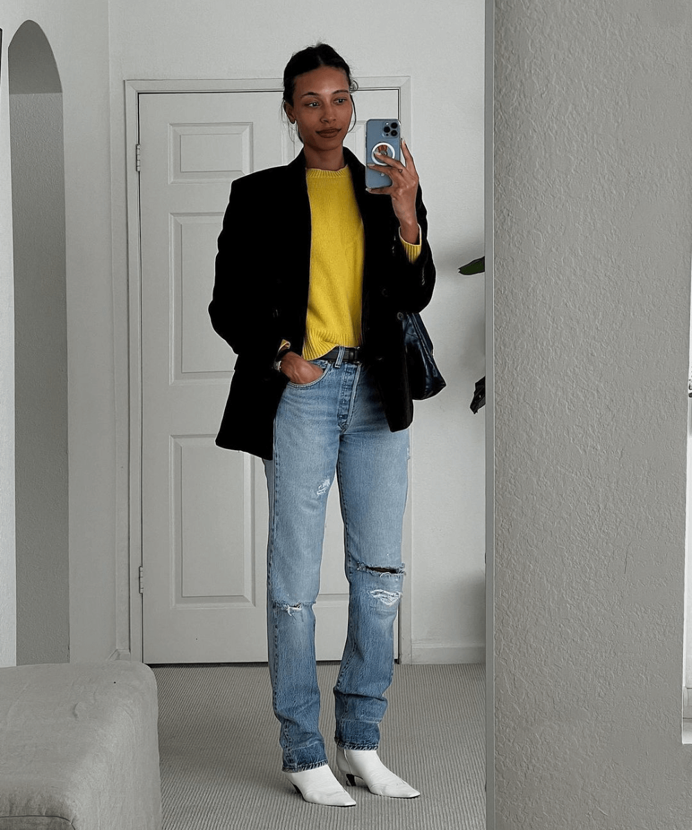 TyLynn Nguyen - calça jeans, tricot amarelo e blazer preto com botas western brancas - inverno 2023 - inverno - foto na frente do espelho - https://stealthelook.com.br