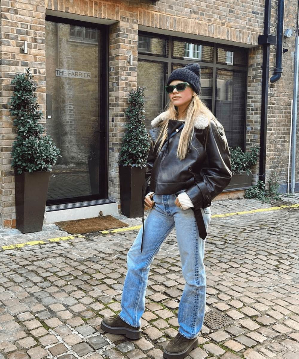 Sofia Richie - calça jeans, casaco de couro preto, gorro e botas - Sofia Richie - inverno - mulher loira em pé na rua usando touca - https://stealthelook.com.br