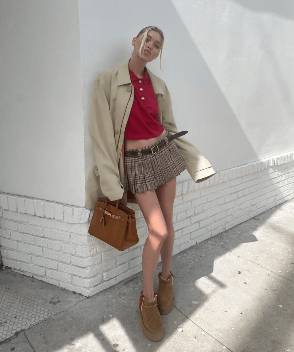 Elsa Hosk - minissaia xadrez, bota ugg, camiseta polo vermelha e trench coat - bota tendência - inverno - modelo em pé na rua - https://stealthelook.com.br