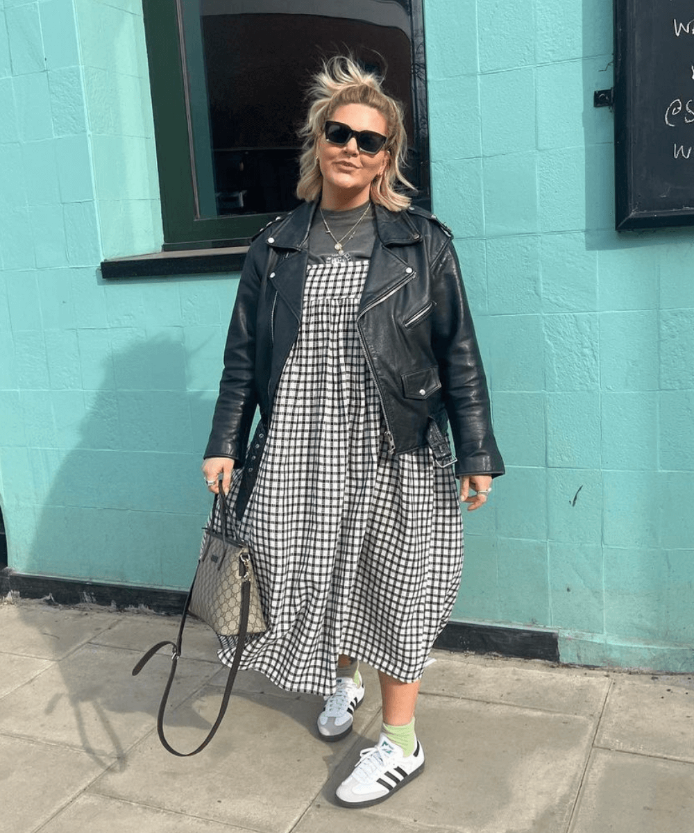 Libby Faulkner - vestido longo xadrez, jaqueta de couro preta e tênis adidas - looks de festa junina - inverno - em pé na rua usando óculos de sol - https://stealthelook.com.br
