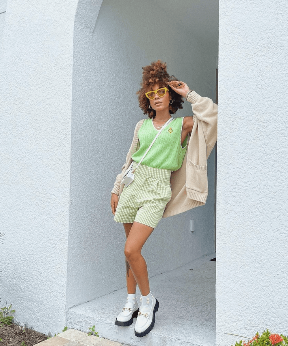 @thenotoriouskia - shorts listrado verde, blusa regata verde, cardigã bege e mocassim branco - looks de inverno - outono - mulher negra andando na rua usando óculos de sol - https://stealthelook.com.br
