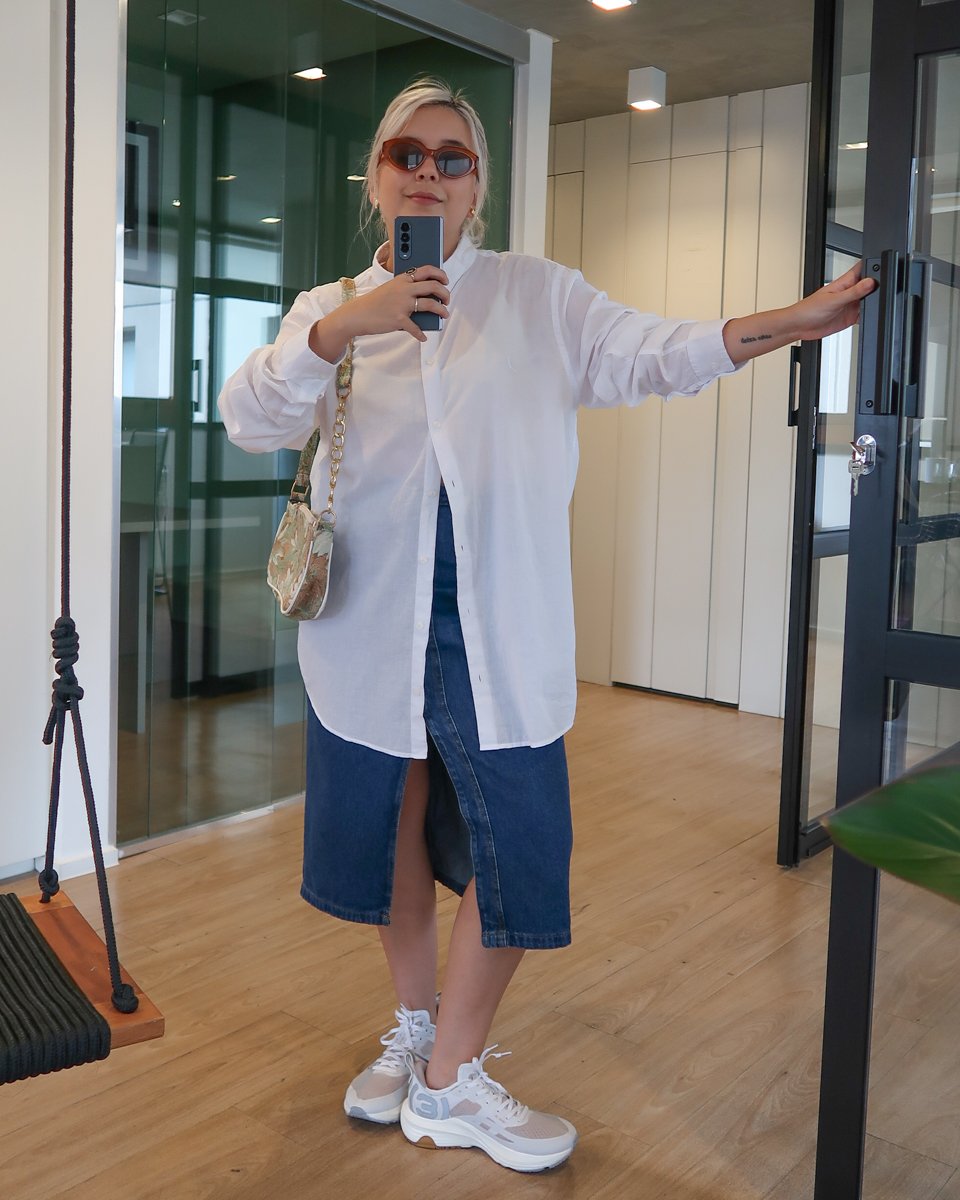 Isadora Diógenes - saia midi jeans, camisa branca oversized e tênis azul olympikus - tênis de corrida - verão - foto na frente do espelho - https://stealthelook.com.br