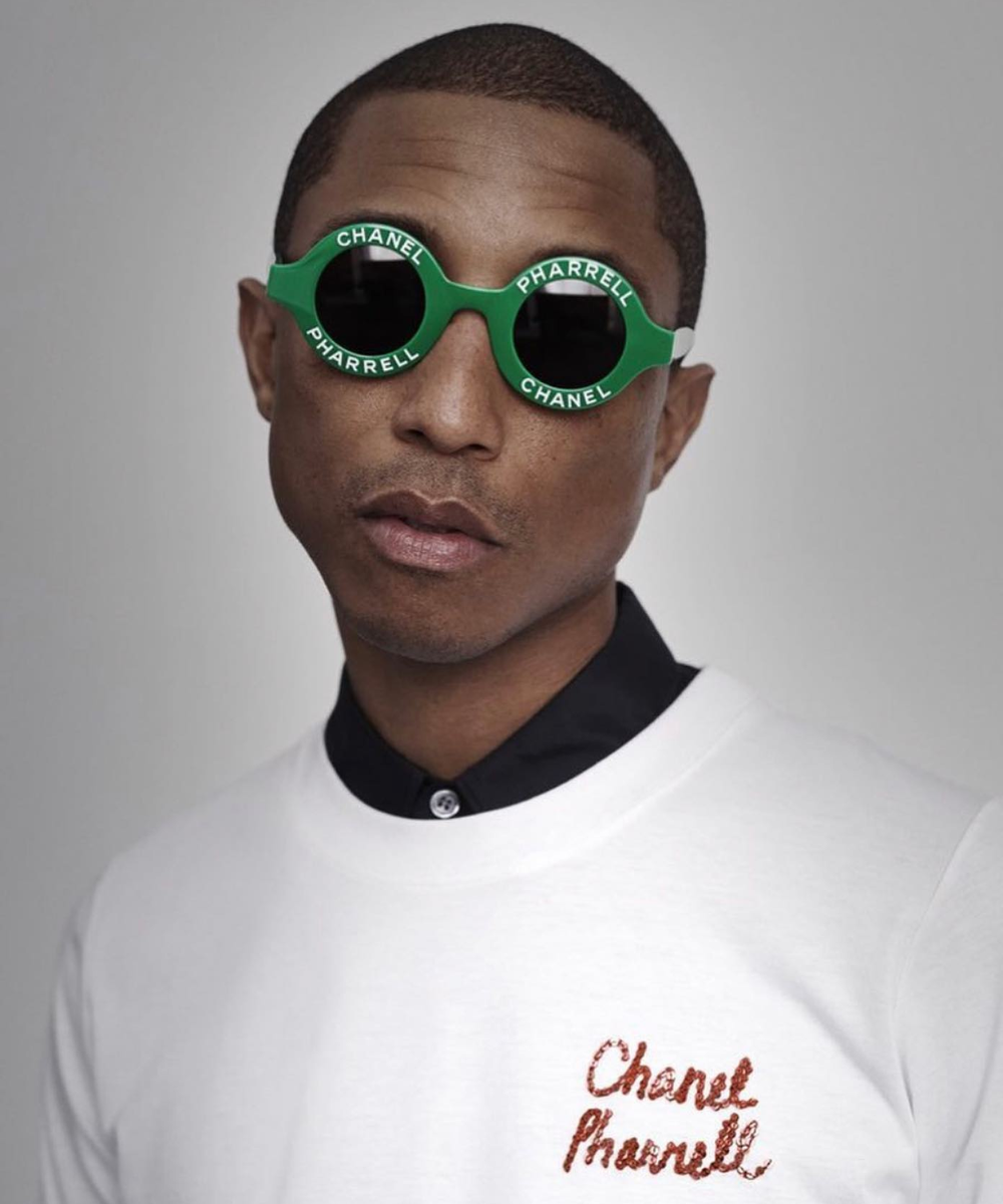 Pharrell Williams X Chanel - t-shirt branca e óculos redondo verde - Pharrell Williams - primavera - foto do rosto do cantor usando uma blusa branca como escrito 