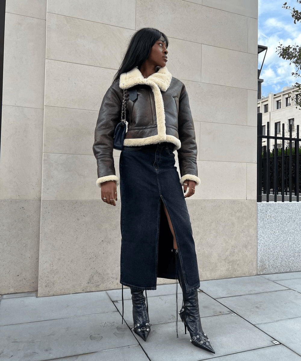 @georgia_3.0 - saia midi jeans, bota de cano longo preta e casaco com pelúcia - saias tendência - inverno - mulher negra andando na rua - https://stealthelook.com.br