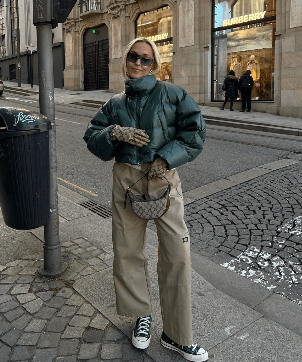 Sofia Coelho - calça bege cargo, jaqueta puffer verde, luva, óculos de sol e tênis - calça bege - inverno - mulher loira andando na rua usando óculos de sol - https://stealthelook.com.br