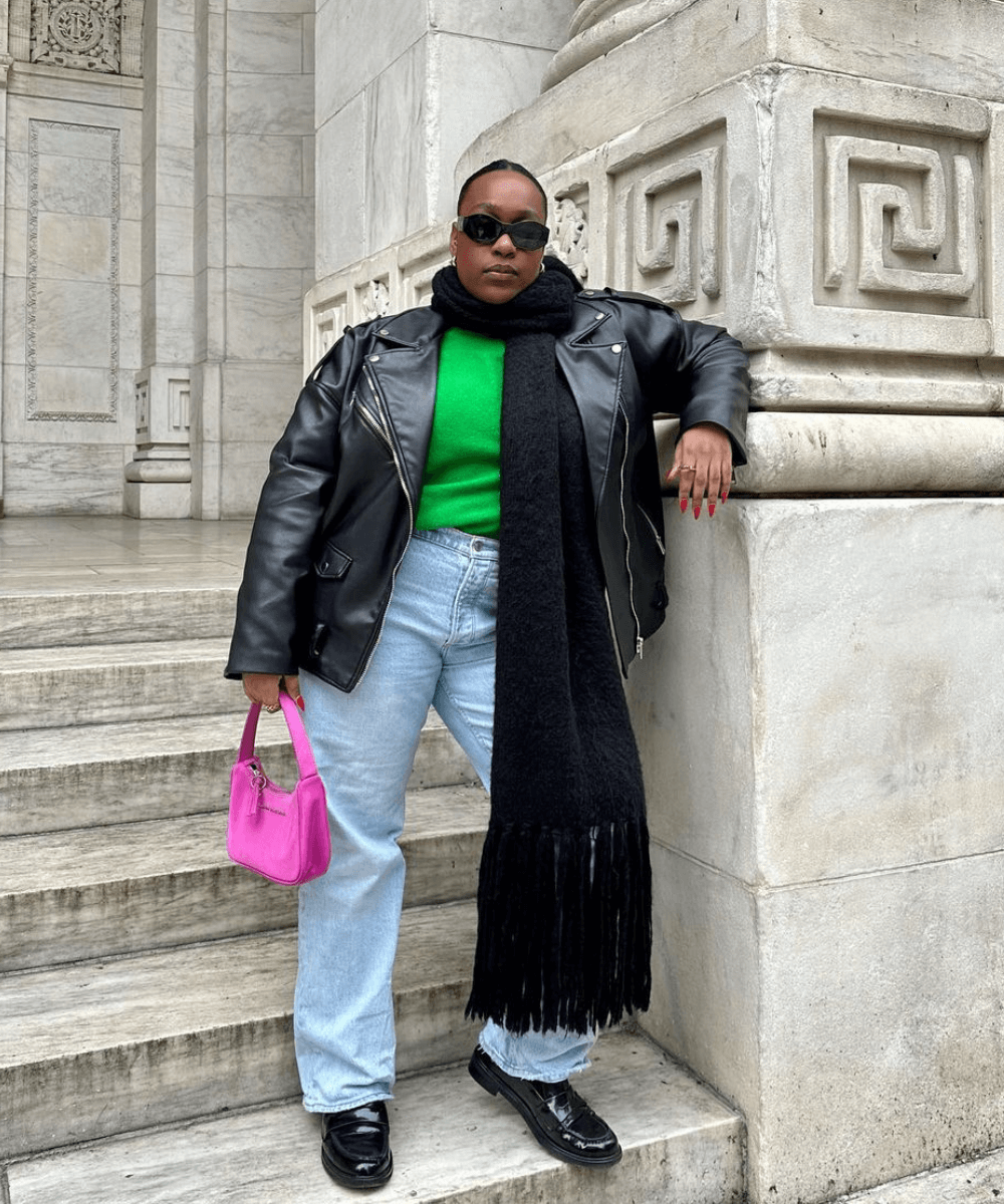 Aniyah Morinia - calça jeans, tricot verde, cachecol preto, jaqueta de couro e bota - looks com tricô - inverno - mulher negra em pé na rua usando óculos de sol - https://stealthelook.com.br