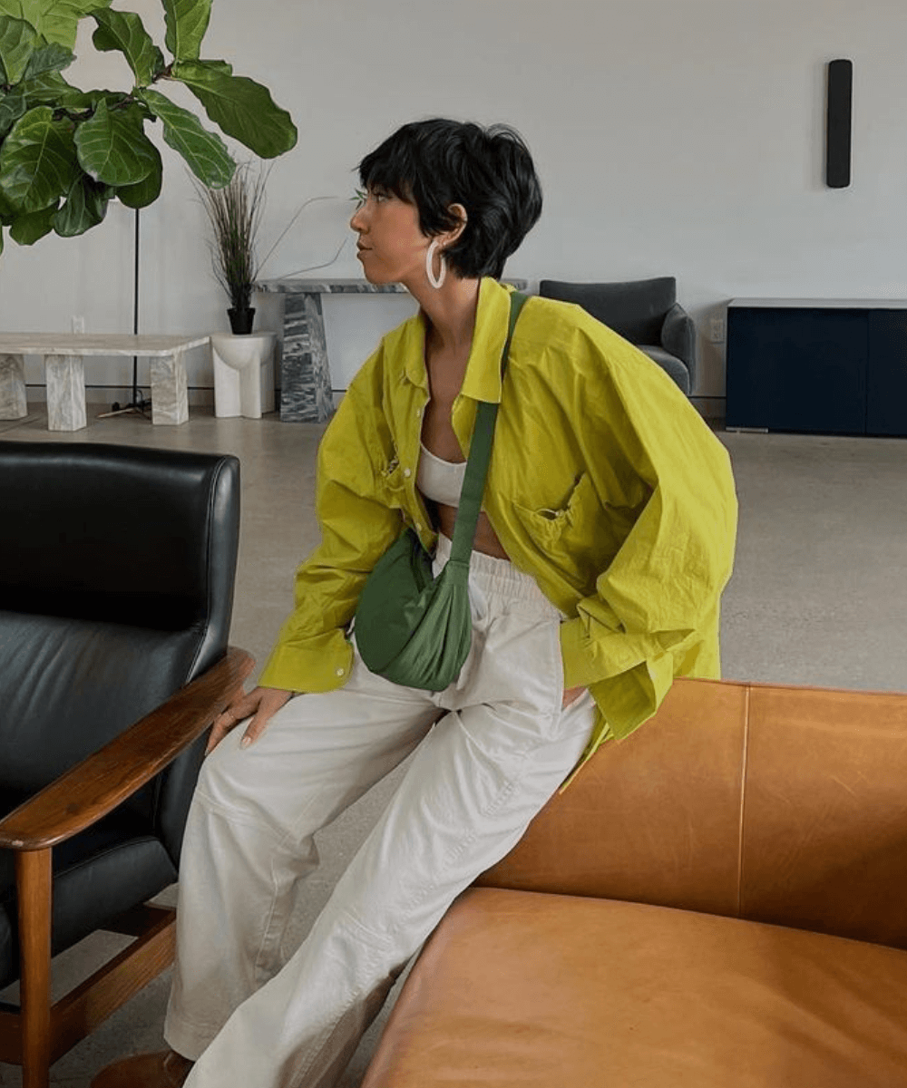 Stephanie Arant - calça branca, parte de cima verde lima - escova secadora - outono - mulher sentada em um sofá olhando para o lado - https://stealthelook.com.br