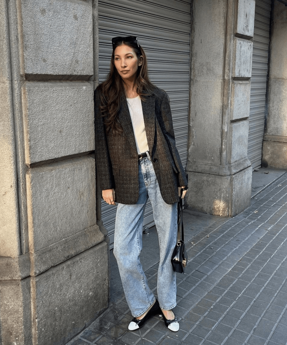 Felicia Akerstrom - calça jeans, sapatilha preta e branca, t-shirt e blazer cinza - looks com jeans - outono - mulher morena em pé na rua - https://stealthelook.com.br