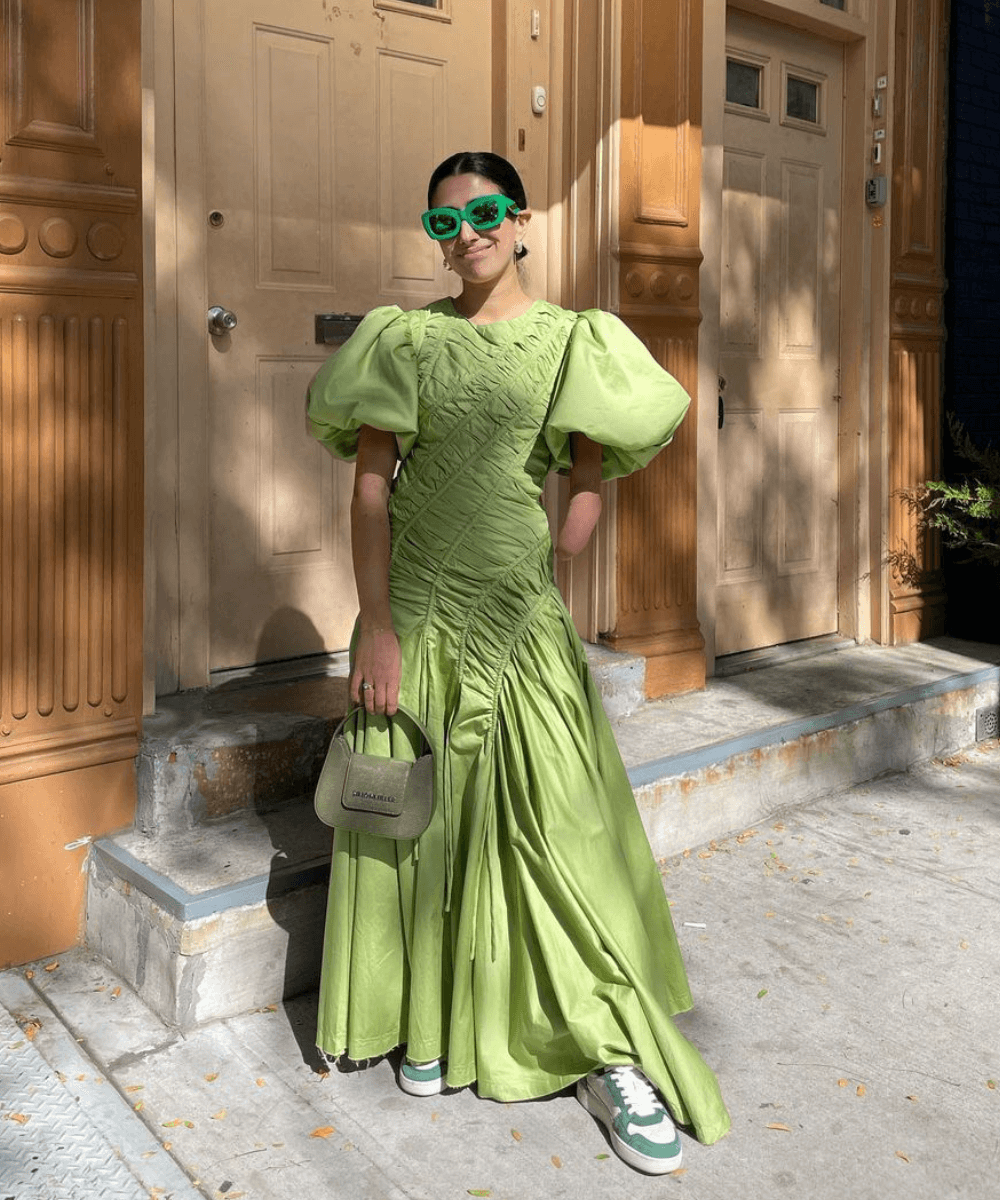 @aprillockhart - vestido verde longo de mangas bufantes, tênis verde e óculos escuros - looks com vestido - verão - mulher em pé na rua usando óculos de sol - https://stealthelook.com.br