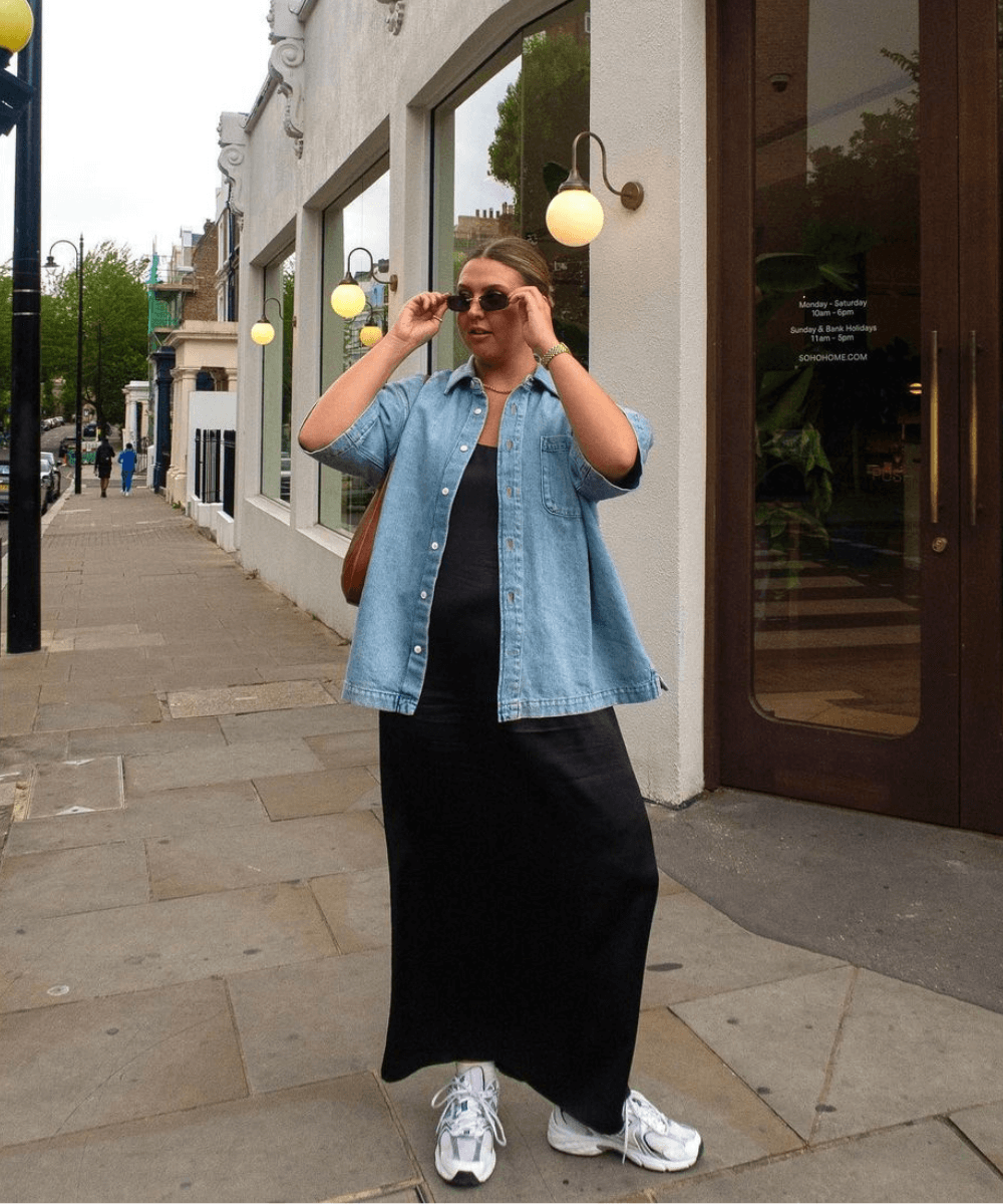 Madison Eley - vestido longo preto, tênis esportivos e camisa jeans de manga curta - looks com vestido - verão - mulher loira em pé na rua usando óculos de sol - https://stealthelook.com.br