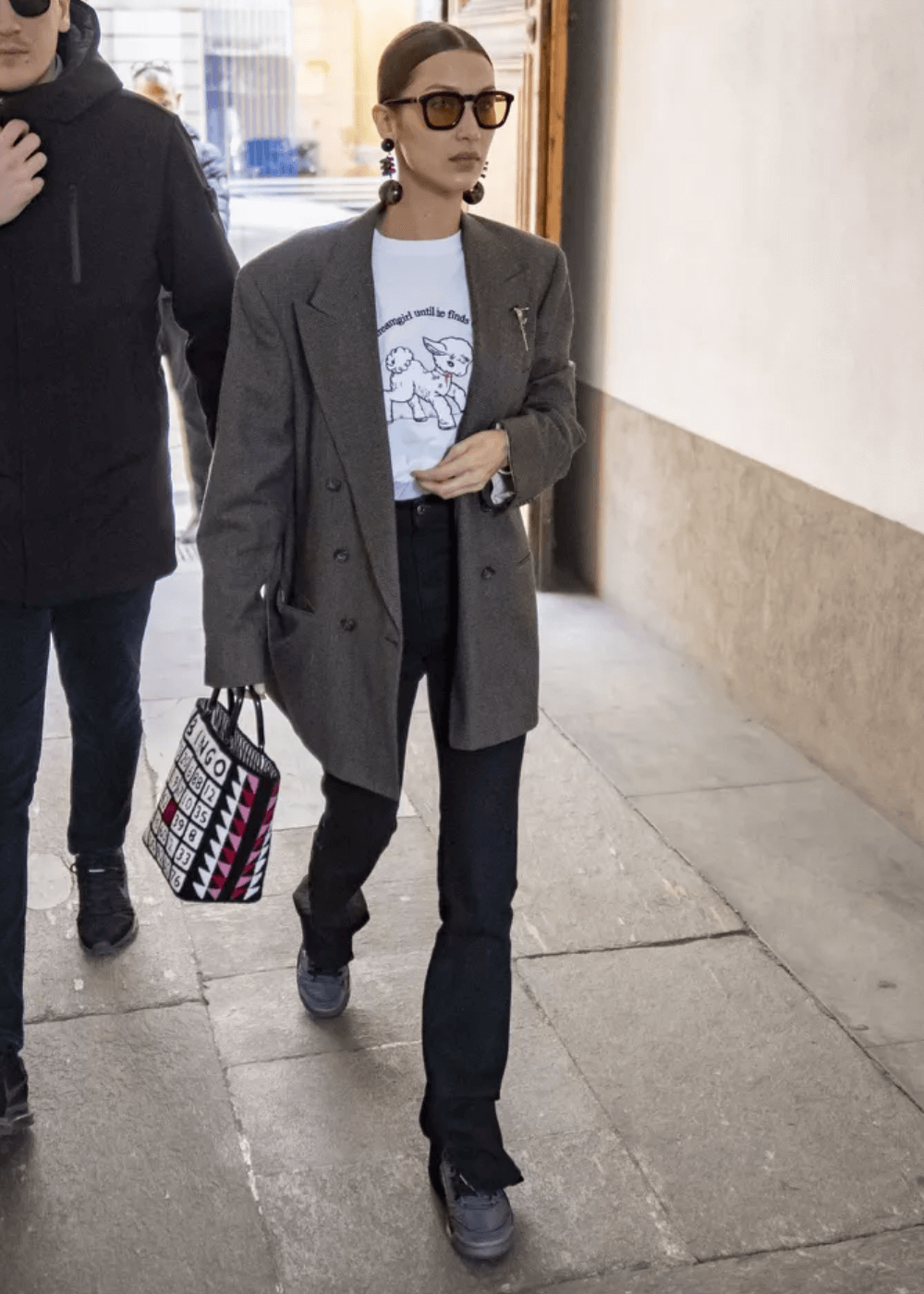 Bella Hadid - calça jeans, t-shirt estampada, blazer oversized e tênis preto - Bella Hadid - outono - modelo andando na rua usando óculos de sol - https://stealthelook.com.br