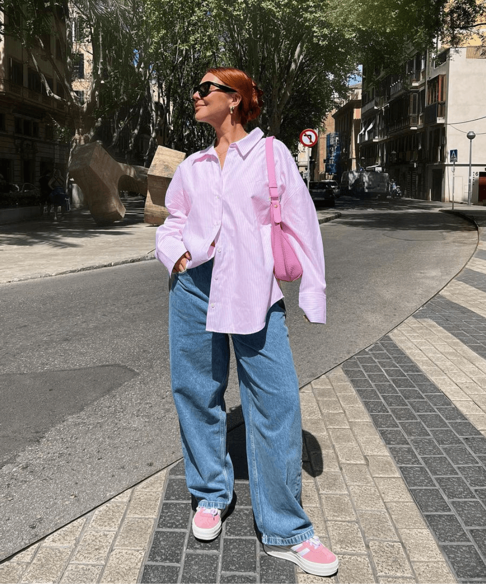 Ellie Beatrice Joslin - calça jeans ampla, tênis rosa e camisa social rosa oversized - look de trabalho - outono - mulher em pé na rua usando óculos de sol - https://stealthelook.com.br