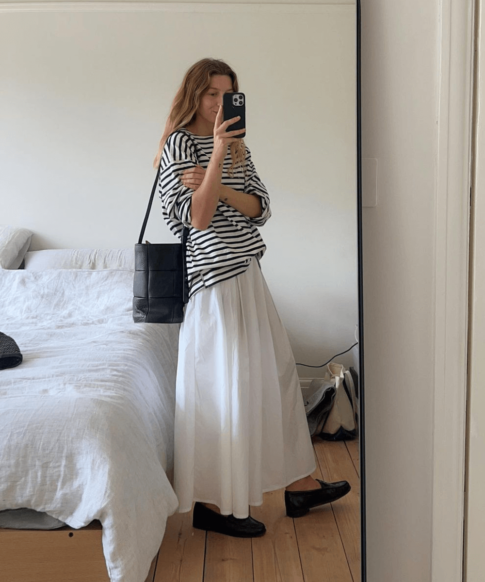 Brittany Bathgate - saia longa branca, t-shirt listrada oversized e mocassim preto - look de trabalho - verão - foto na frente do espelho - https://stealthelook.com.br