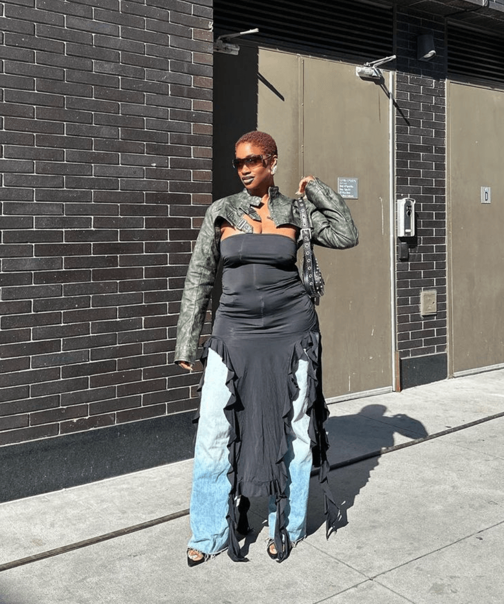 Yolande Macon - calça jeans, vestido preto de babados e jaqueta de couro preta - tendência Y2K - outono - mulher negra em pé na rua usando óculos de sol - https://stealthelook.com.br