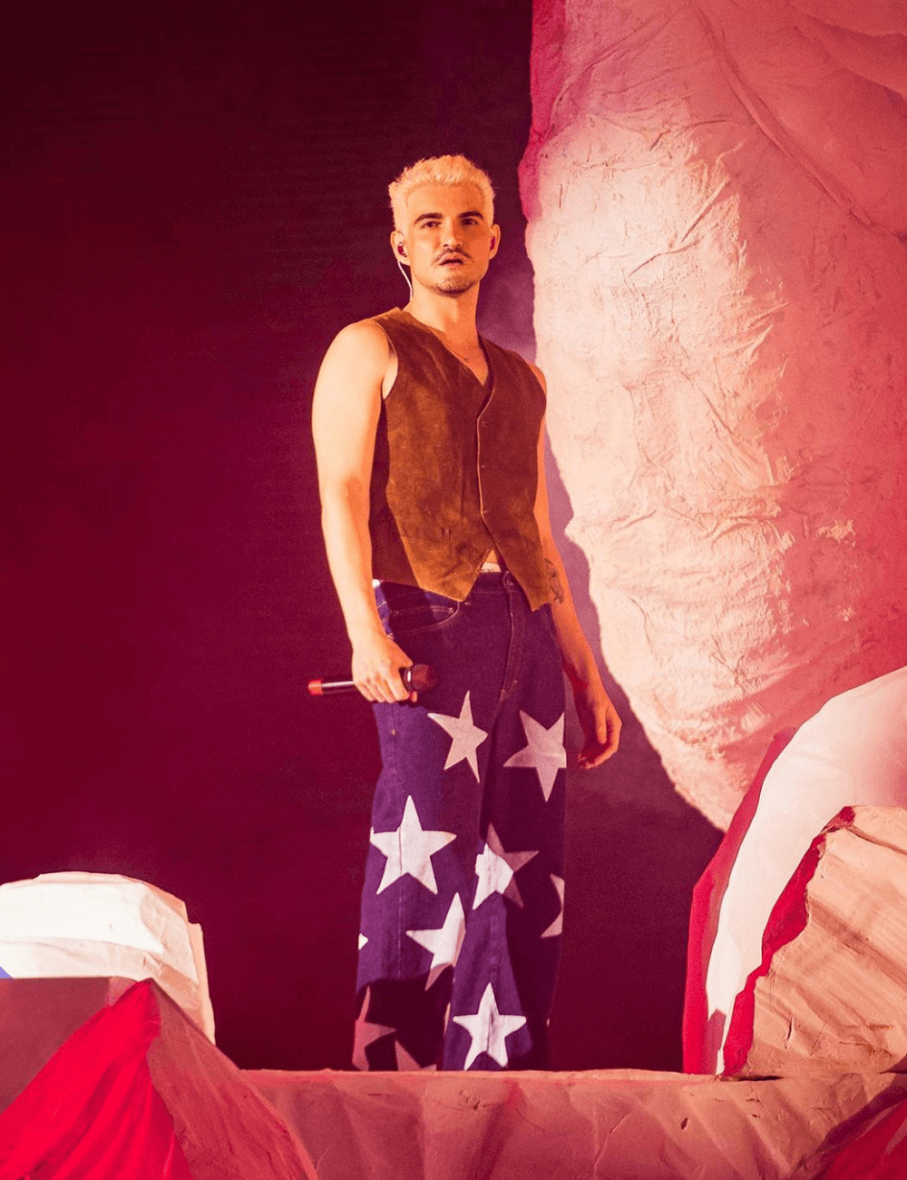 Jão - calça com estrela nos joelhos e colete marrom - The Town - inverno - homem em pé em cima de um palco - https://stealthelook.com.br