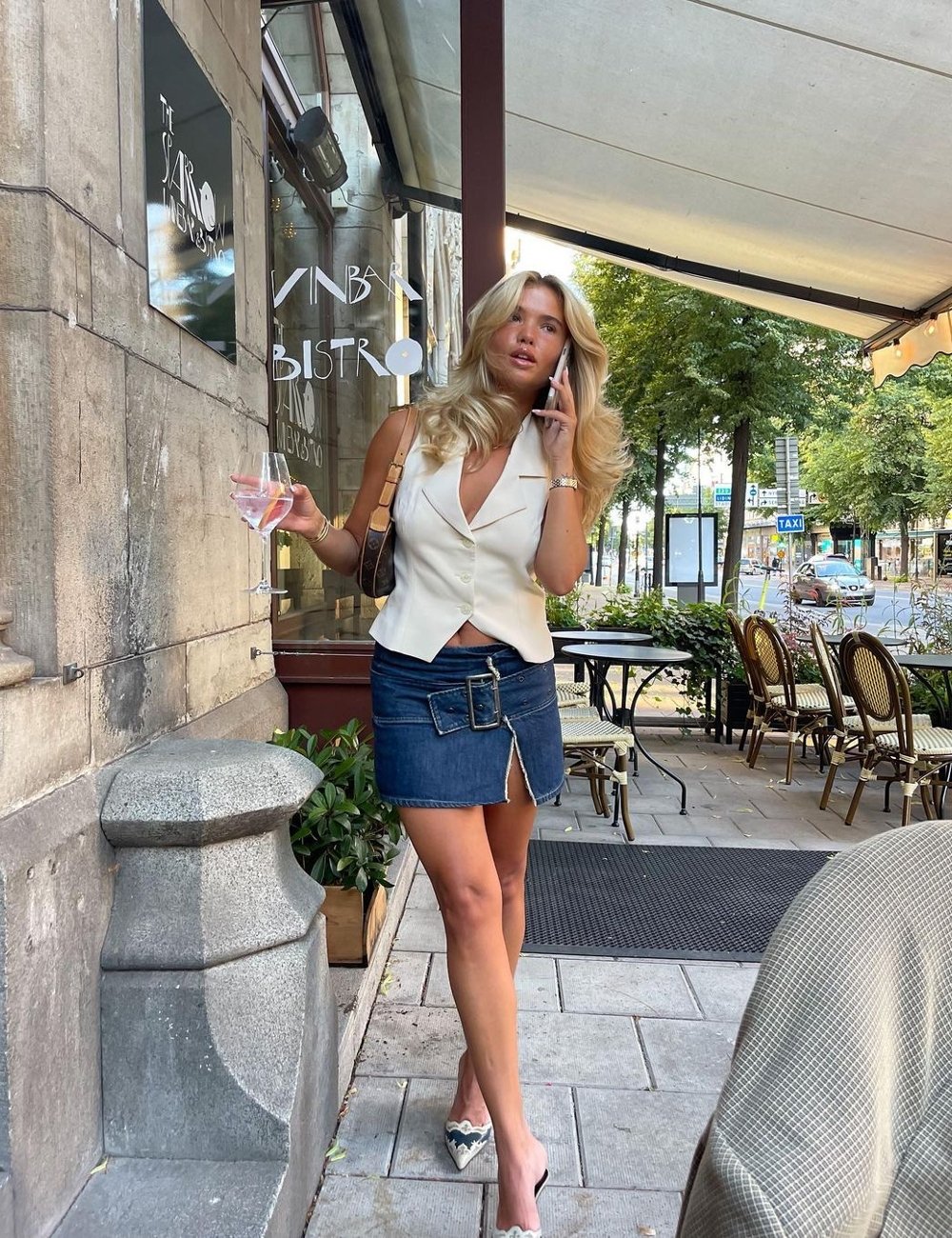 Matilda Djerf - colete, saia jeans e mule - looks fáceis - verão - street style - https://stealthelook.com.br