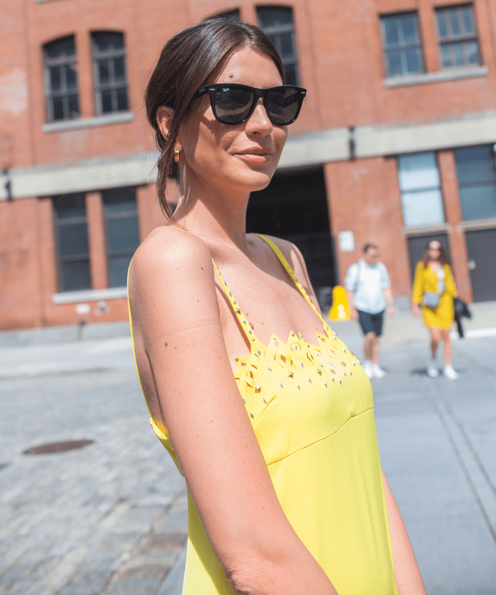 Manuela Bordasch - vestido amarelo longo e óculos RayBan - looks da fashion week - verão - mulher parada em pé sorrindo usando óculos - https://stealthelook.com.br