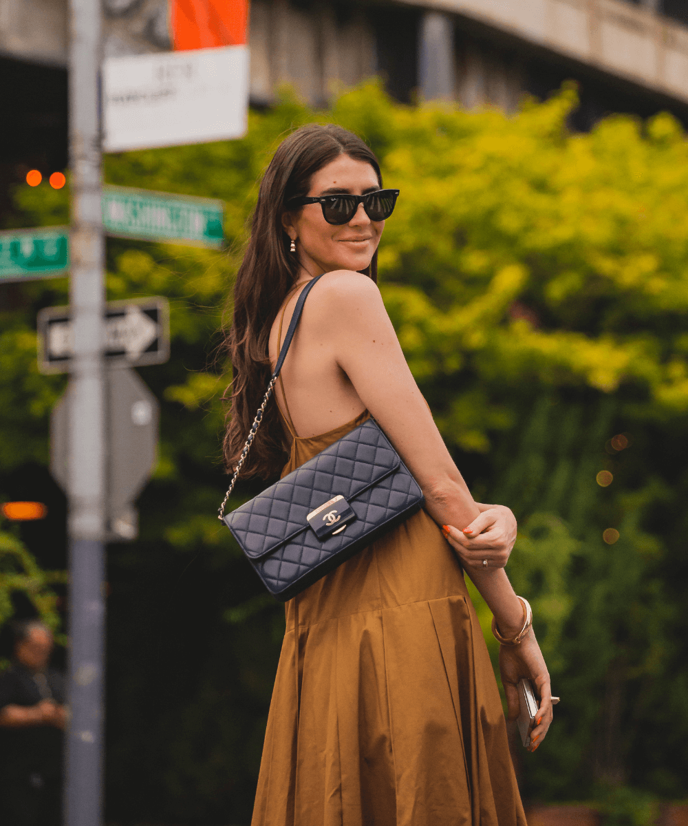 Manuela Bordasch - vestido marrom soltinho e óculos de sol RayBan - looks da fashion week - verão - mulher em pé na rua usando óculos de sol - https://stealthelook.com.br