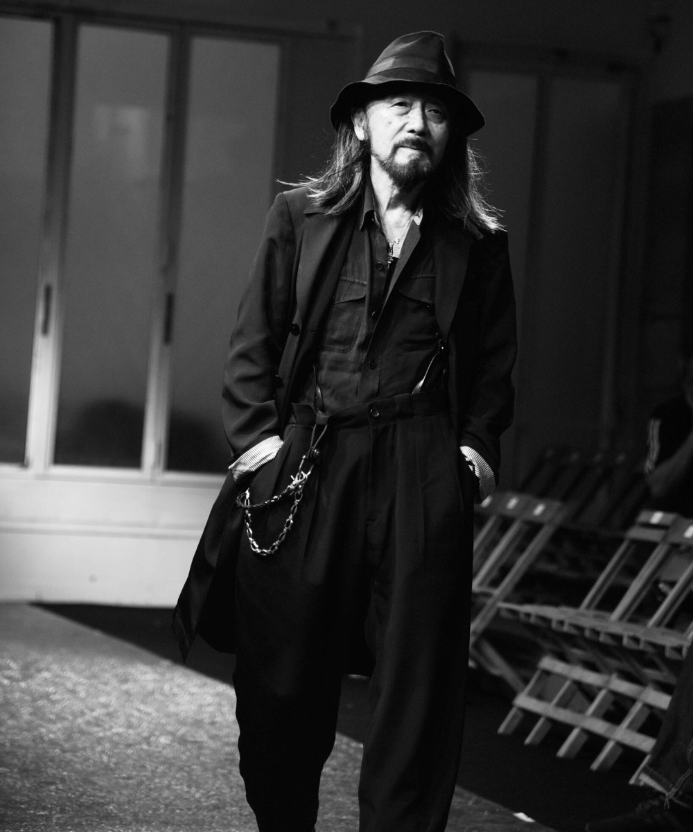 Yohji Yamamoto - roupa inteira preta com chapéu e sobretudo - asiáticos na moda - inverno - homem asiático andando - https://stealthelook.com.br