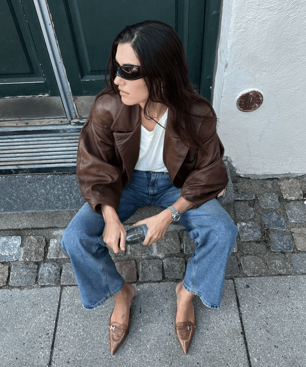 @iliridakrasniqi - calça jeans, regata branca, jaqueta marrom oversized e scarpin marrom claro - Marrom - outono - mulher morena sentada em uma escada na rua usando óculos de sol - https://stealthelook.com.br