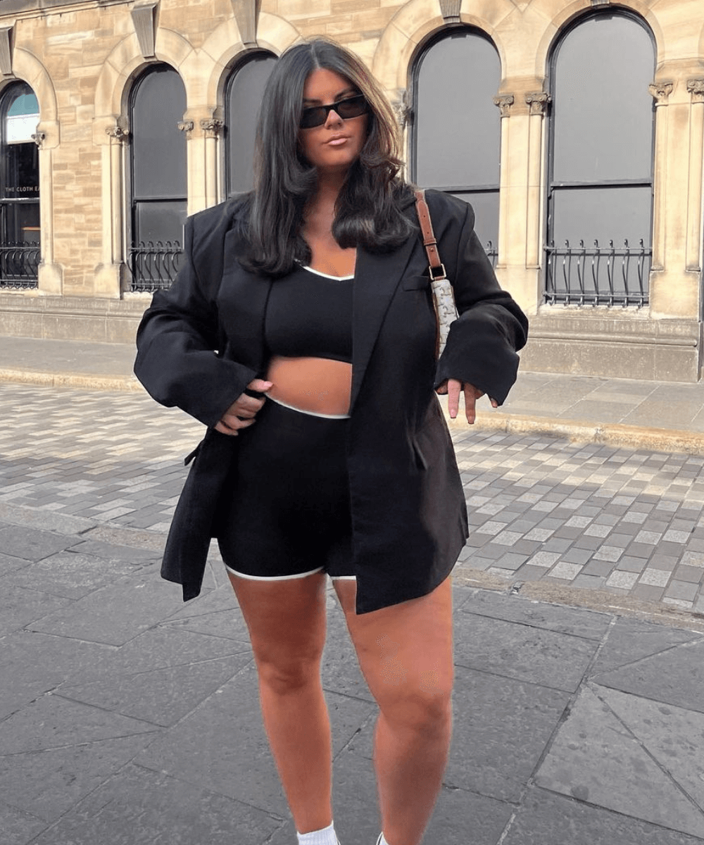 Freya Broni - set de academia preto, blazer e tênis - sportswear - verão - mulher em pé na rua usando óculos de sol - https://stealthelook.com.br