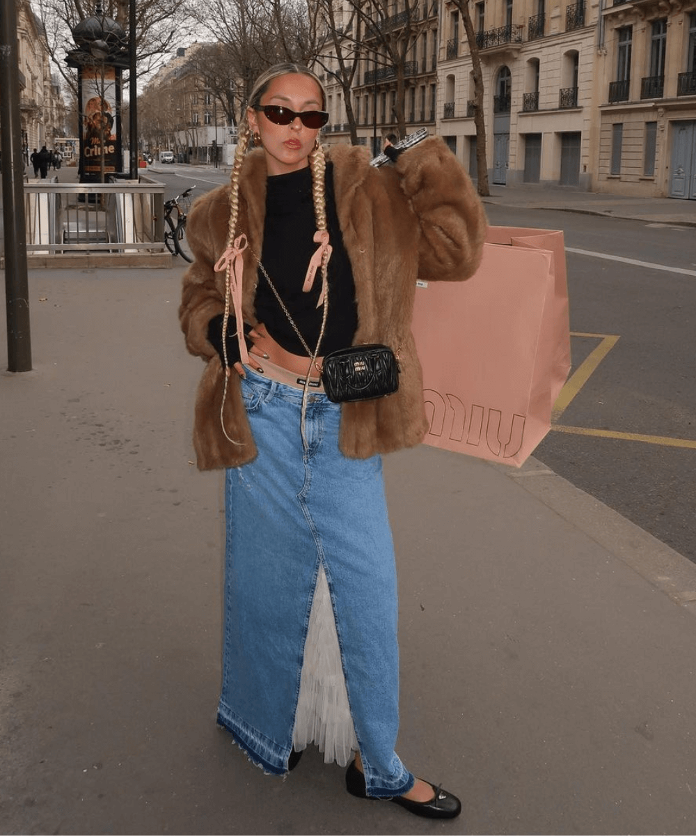 Sofia Coelho - saia jeans longa, top e jaqueta de manga longa - tendências de jeans - inverno - mulher loira andando na rua usando óculos de sol - https://stealthelook.com.br