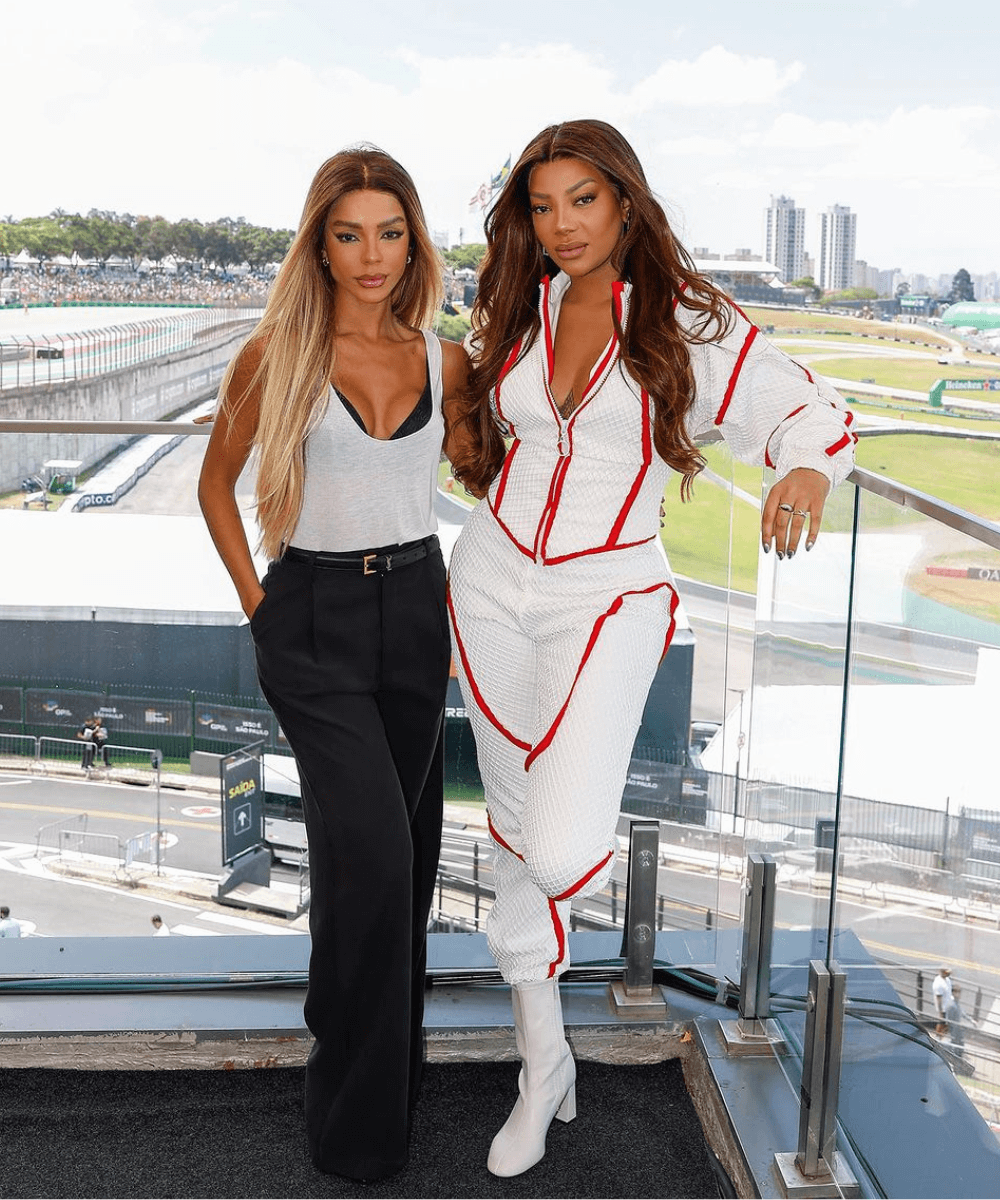 Ludmilla e Brunna Gonçalves - macacão branco oversized - looks do GP da Fórmula 1 - primavera - duas mulheres em pé posando para a foto - https://stealthelook.com.br