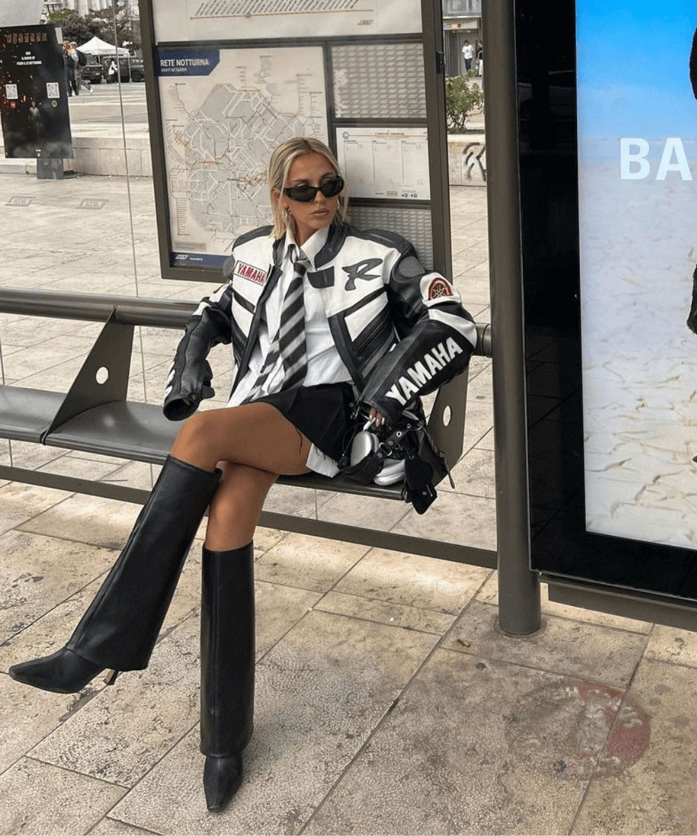 Sofia Coelho - minissaia preta, camisa branca, gravata, bota e jaqueta oversized - look para o show do RBD - outono - mulher sentada em um banco na rua - https://stealthelook.com.br