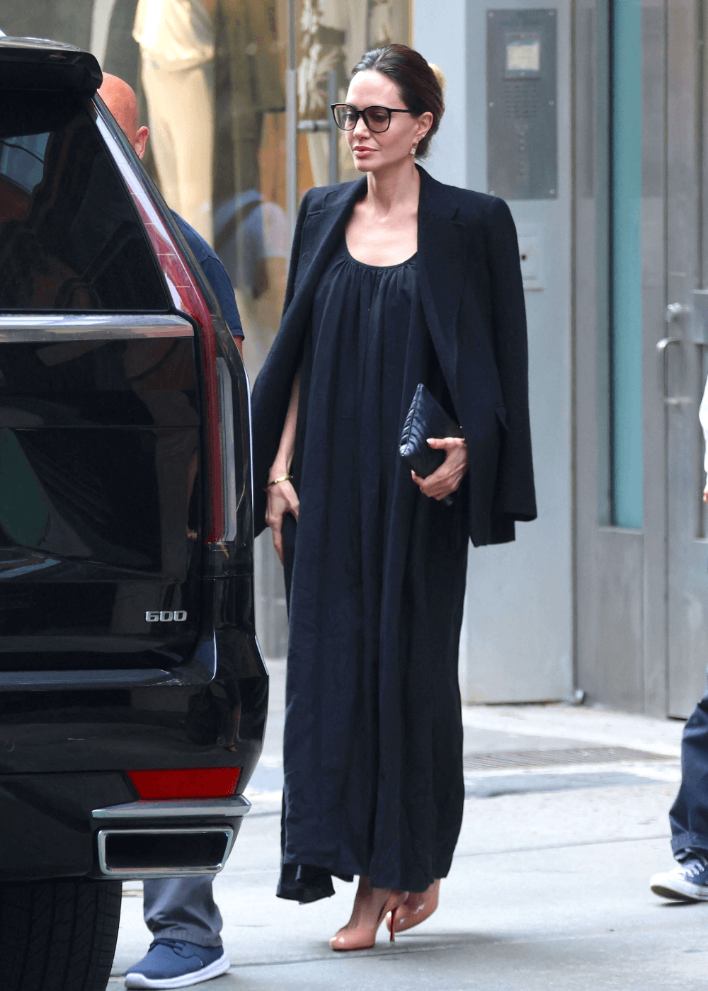 Angelina Jolie - vestido longo preto, scarpins e blazer preto - peças-chave das celebridades - outono - mulher de óculos em pé na rua - https://stealthelook.com.br