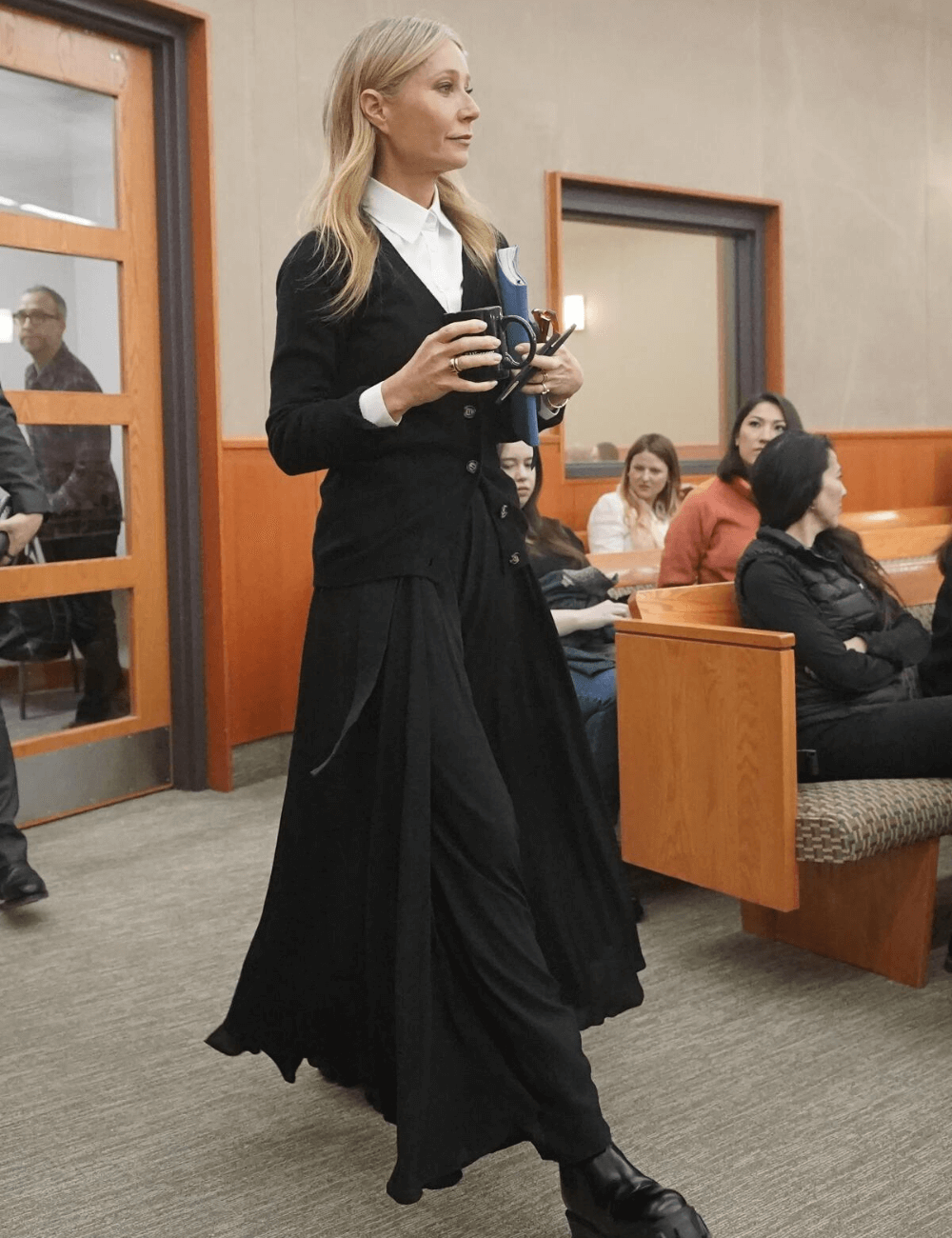 Gwyneth Paltrow - saia longa preta, blusa de manga longa preta e coturnos - Principais tendências 2023 - inverno - mulher loira andando - https://stealthelook.com.br