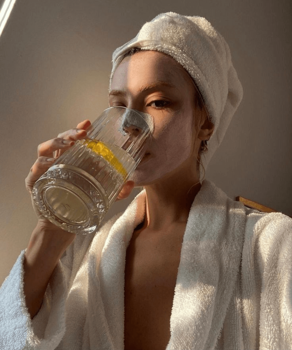 @callmezara_h - roupão branco - sabonete facial - primavera - mulher com toalha enrolada na cabeça, máscara facial, fazendo skincare e bebendo em um copo de vidro - https://stealthelook.com.br