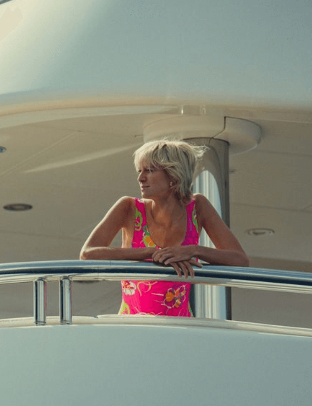 Elizabeth Debicki - maiô floral rosa - Looks da Princesa Diana - verão - atriz debruçada em um barco gravando - https://stealthelook.com.br