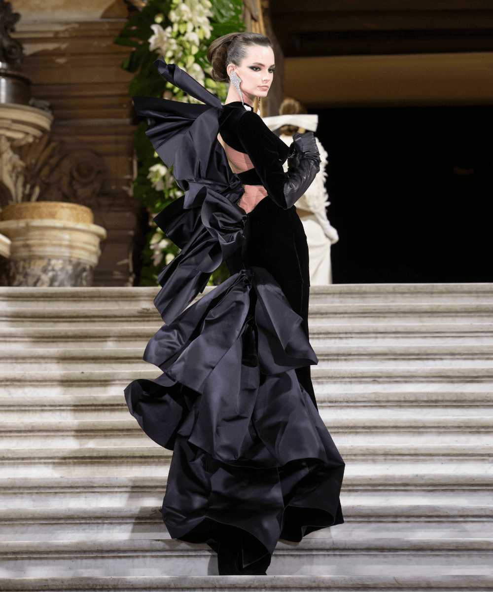 Semana de alta-costura Outono/Inverno 23/24 - vestido preto longo - Stephane Rolland - outono - modelo de costas subindo uma escada grande e longa - https://stealthelook.com.br