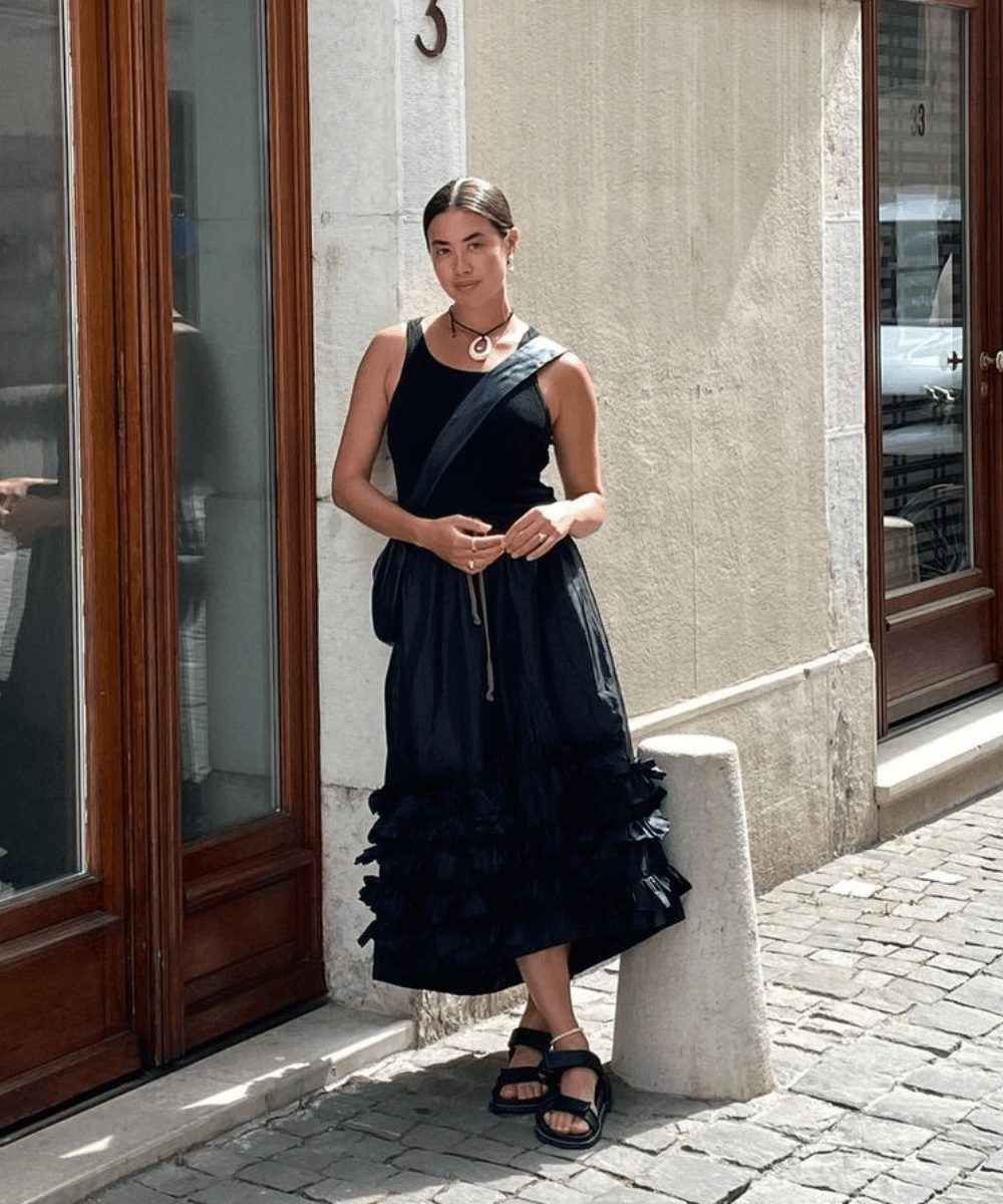 Sasha Mei - vestido preto de babados midi e papete preta - tendências polêmicas - verão - mulher asiática de pé na rua - https://stealthelook.com.br