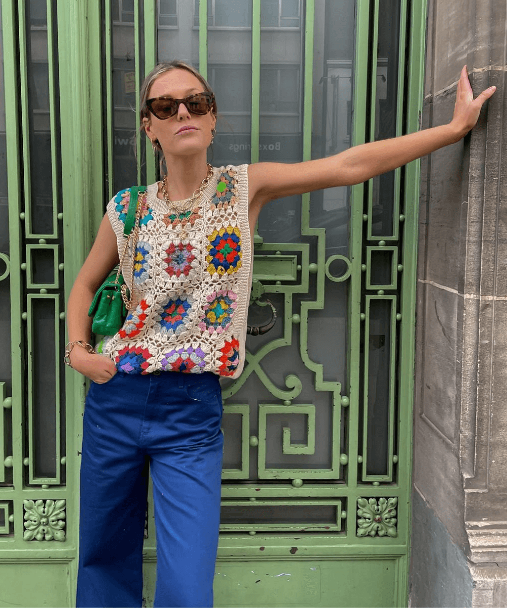 @tinvcb - calça azul e colete de crochê colorido - blusas femininas da moda - verão - mulher loira andando na rua usando óculos de sol - https://stealthelook.com.br