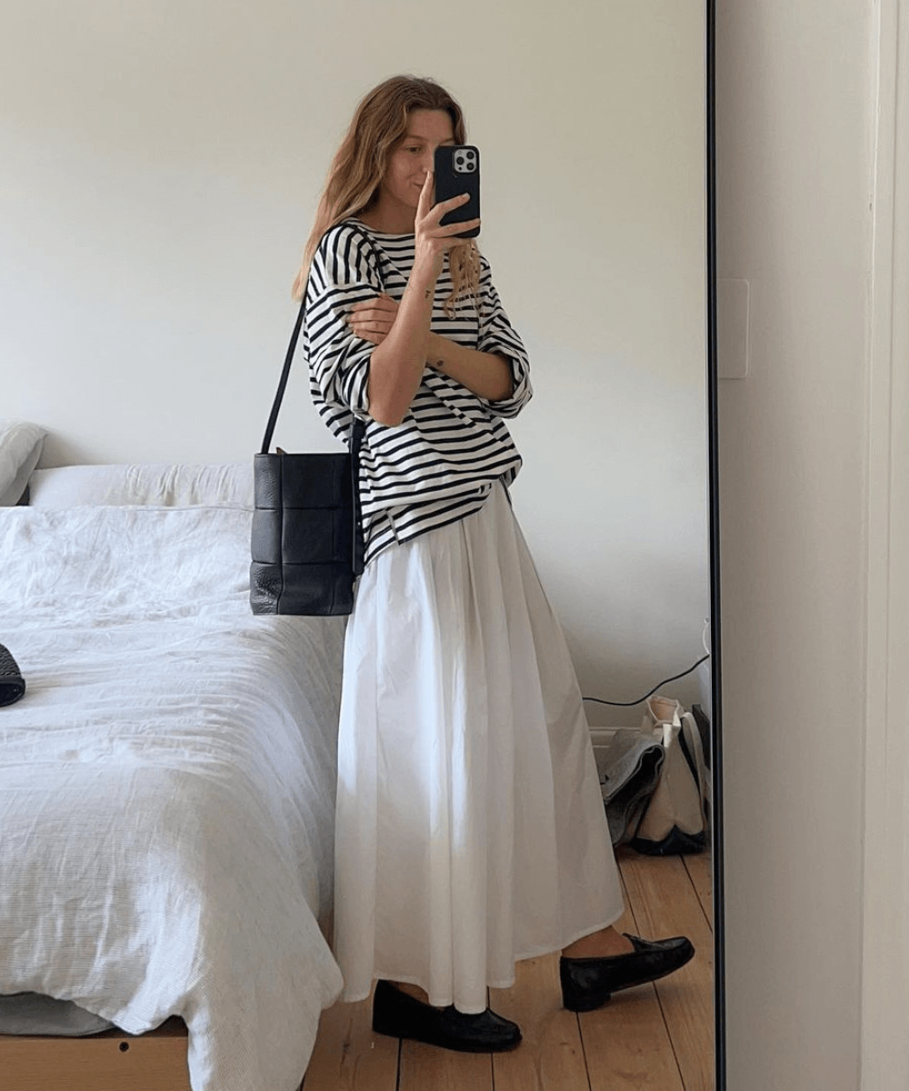 Brittany Bathgate - saia longa branca, mocassims e t-shirt listrada oversized - roupas brancas - verão - mulher tirando foto na frente de um espelho - https://stealthelook.com.br