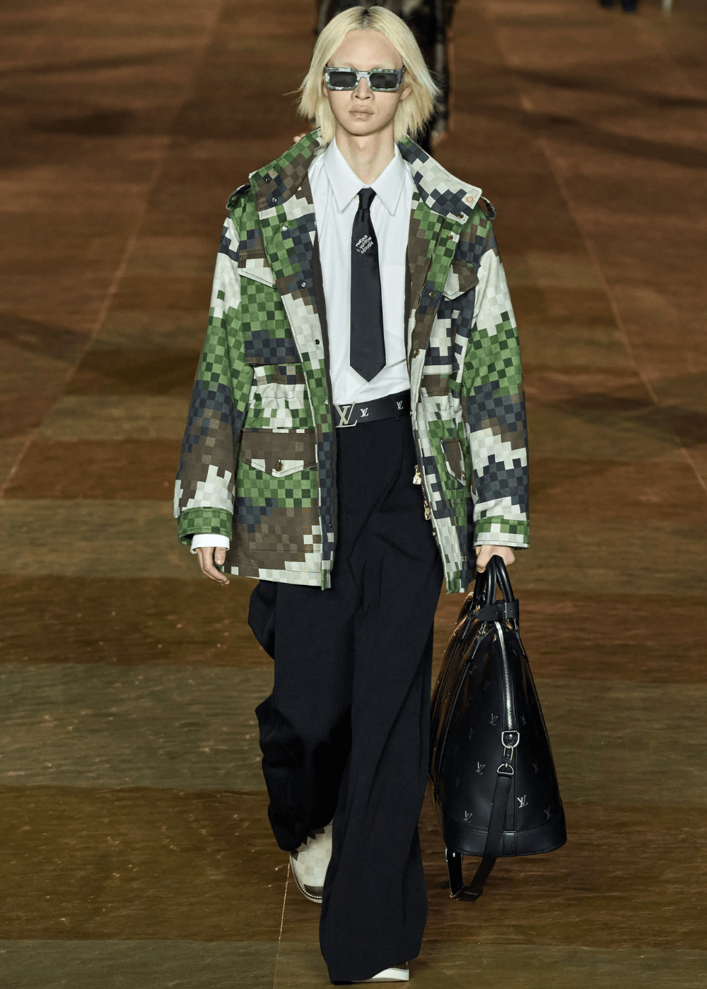 Louis Vuitton Menswear 2024 - jaqueta pixelada em tons de verde, calça preta, camisa branca, gravata preta e óculos - desfiles de moda - primavera - modelos andando na passarela - https://stealthelook.com.br